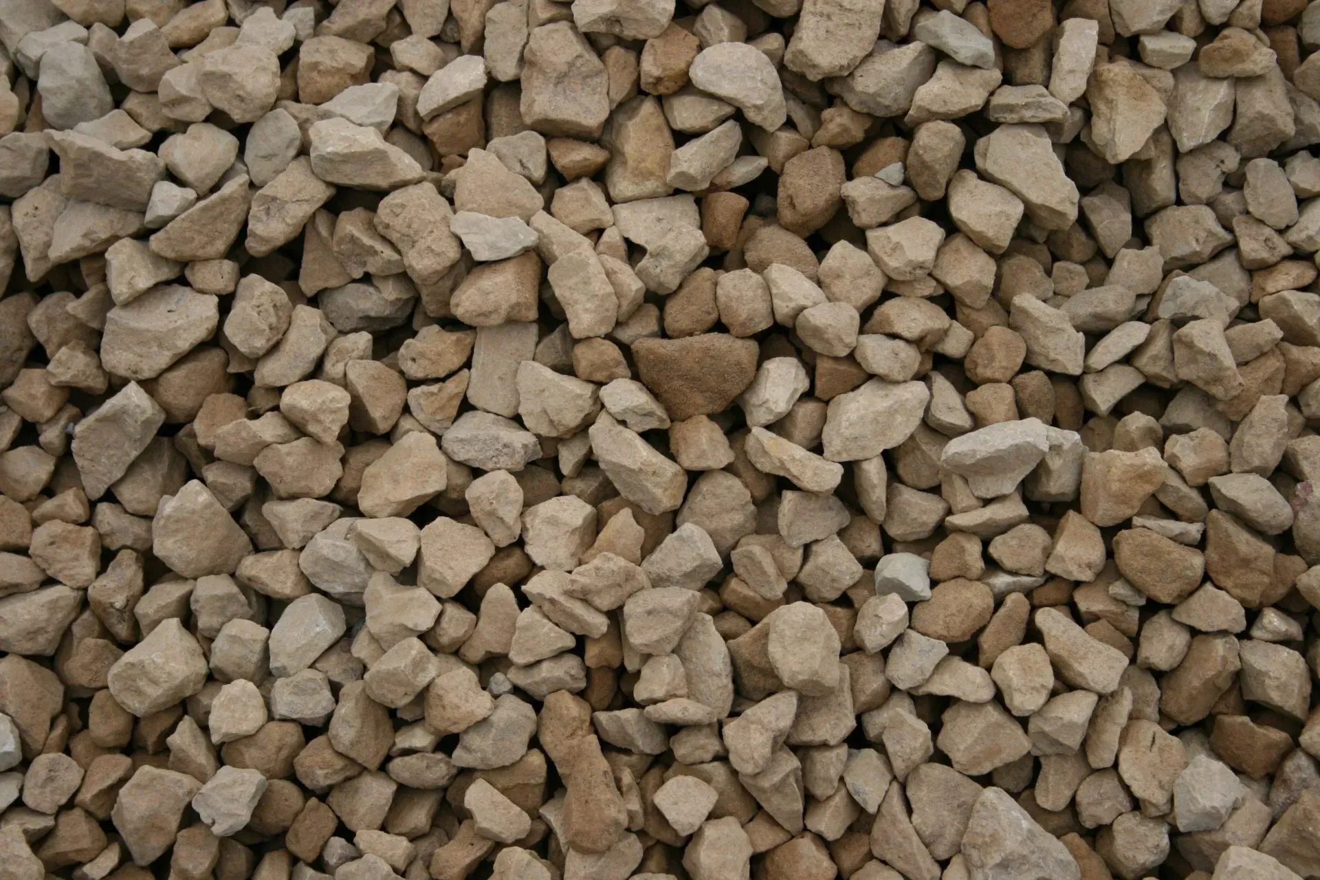 A close-up view of crushed tan and beige limestone gravel.