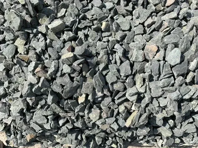 A close-up view of crushed dark gray gravel stones with jagged edges and varying sizes.