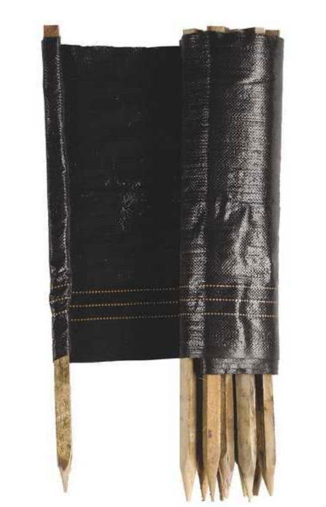 A roll of black silt fence material attached to several pointed wooden stakes.
