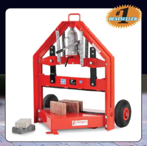 A red manual block splitter for paving stones with a hydraulic jack on wheels, with bricks placed inside the cutting area.