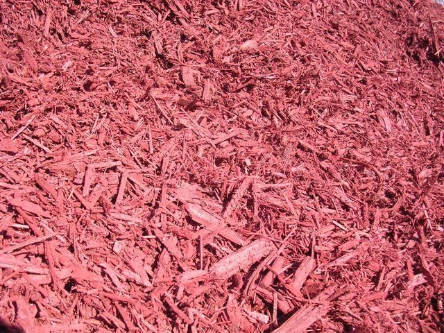 A close-up view of red wood mulch chips used for garden landscaping.