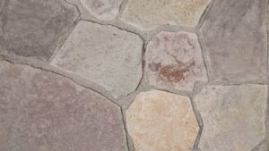 A close-up view of multicolored, irregular flagstones set in gray mortar.