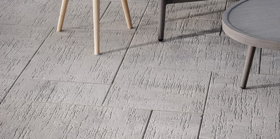 Gray stone tile floor with chair and table legs visible in a minimalist interior