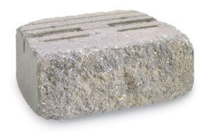 A single gray, rectangular retaining wall block with a split-face textured front and grooves on top.