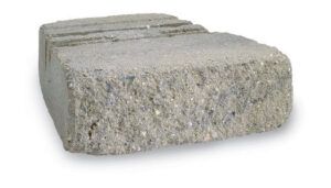 A single, gray, rectangular concrete retaining wall block with a textured, rough-hewn front face.