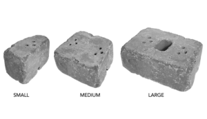 Three grey concrete retaining wall blocks of varying sizes—small, medium, and large—arranged side by side.