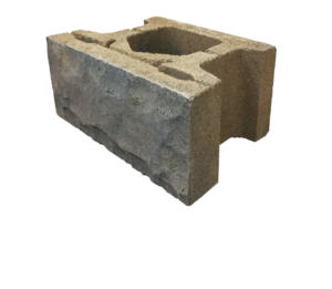 A tan-colored concrete retaining wall block with a textured, stone-like face and a hollow core.