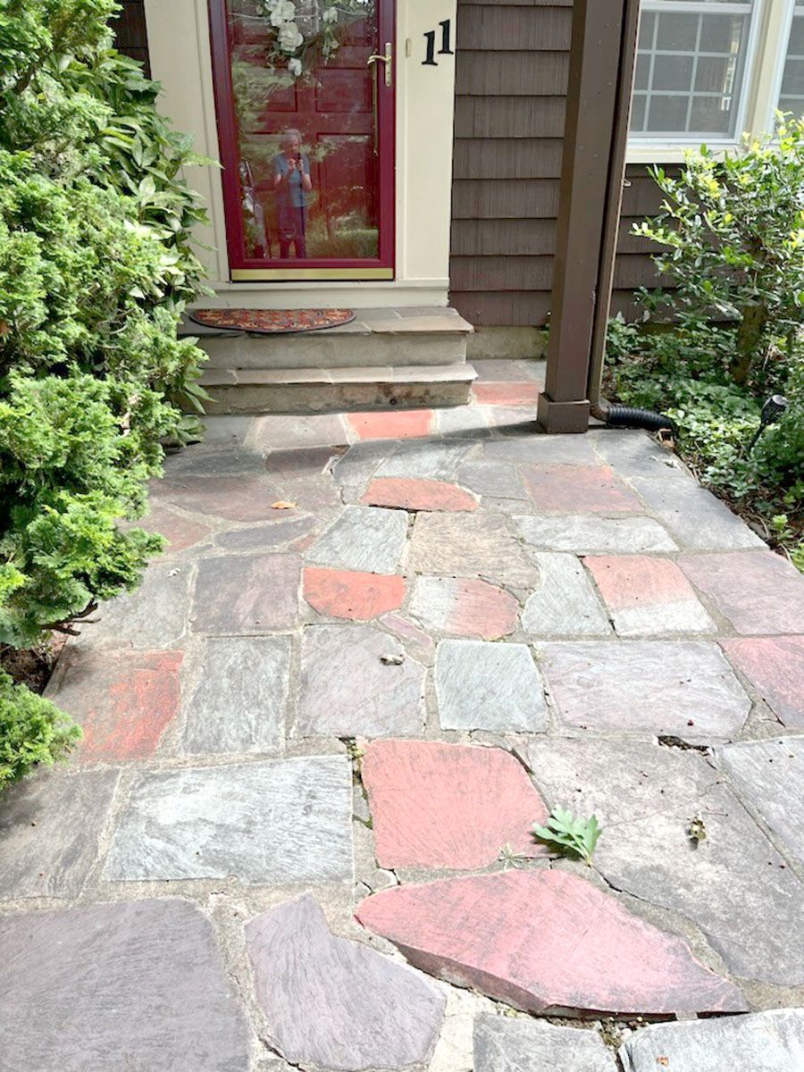 An old stone walkway leading to the front door of a house