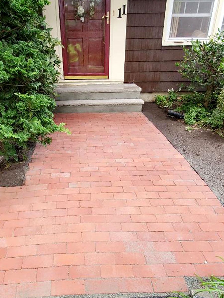 A new brick walkway leading to the front door of a house