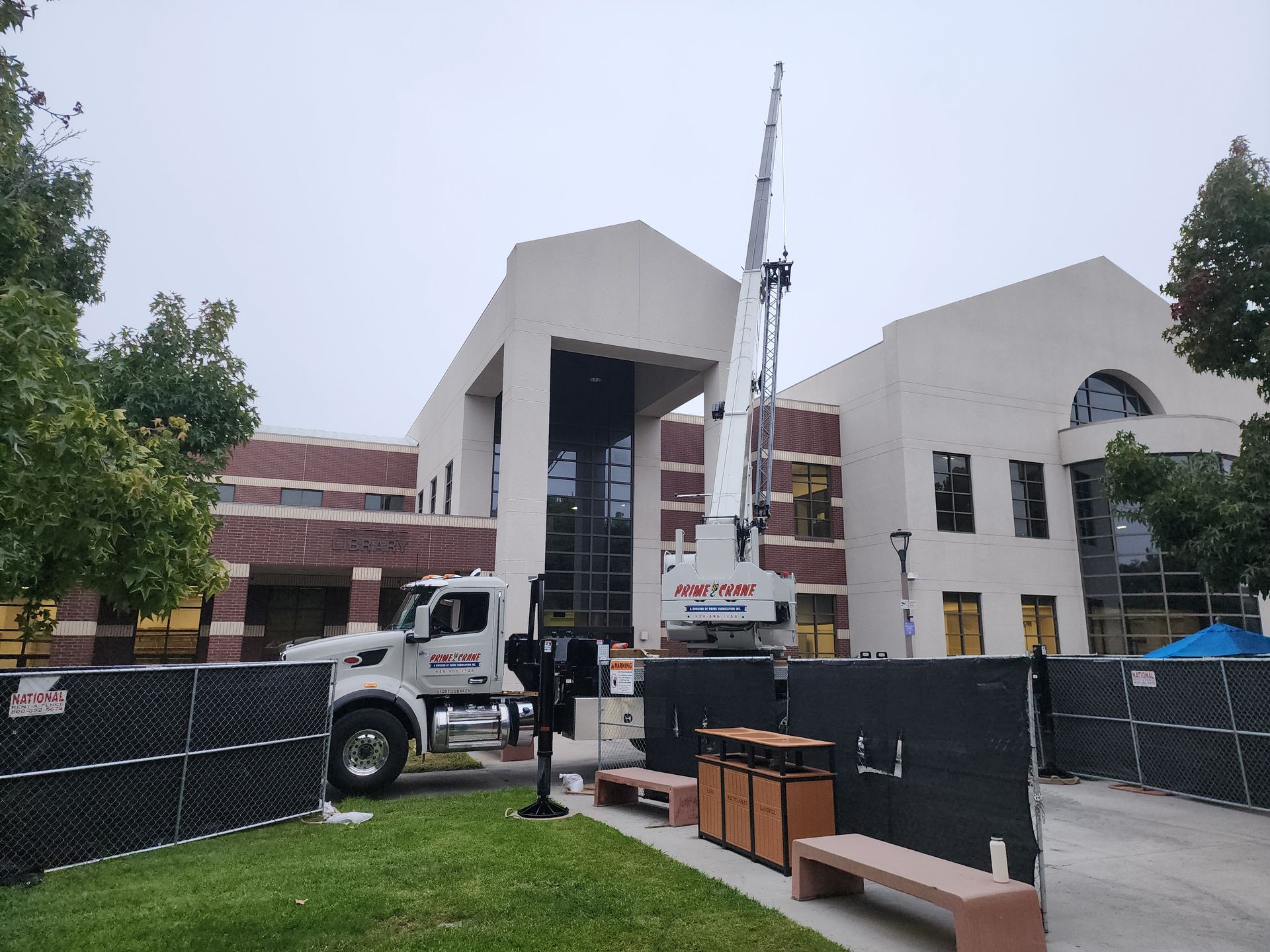 A large white truck is parked in front of a large building