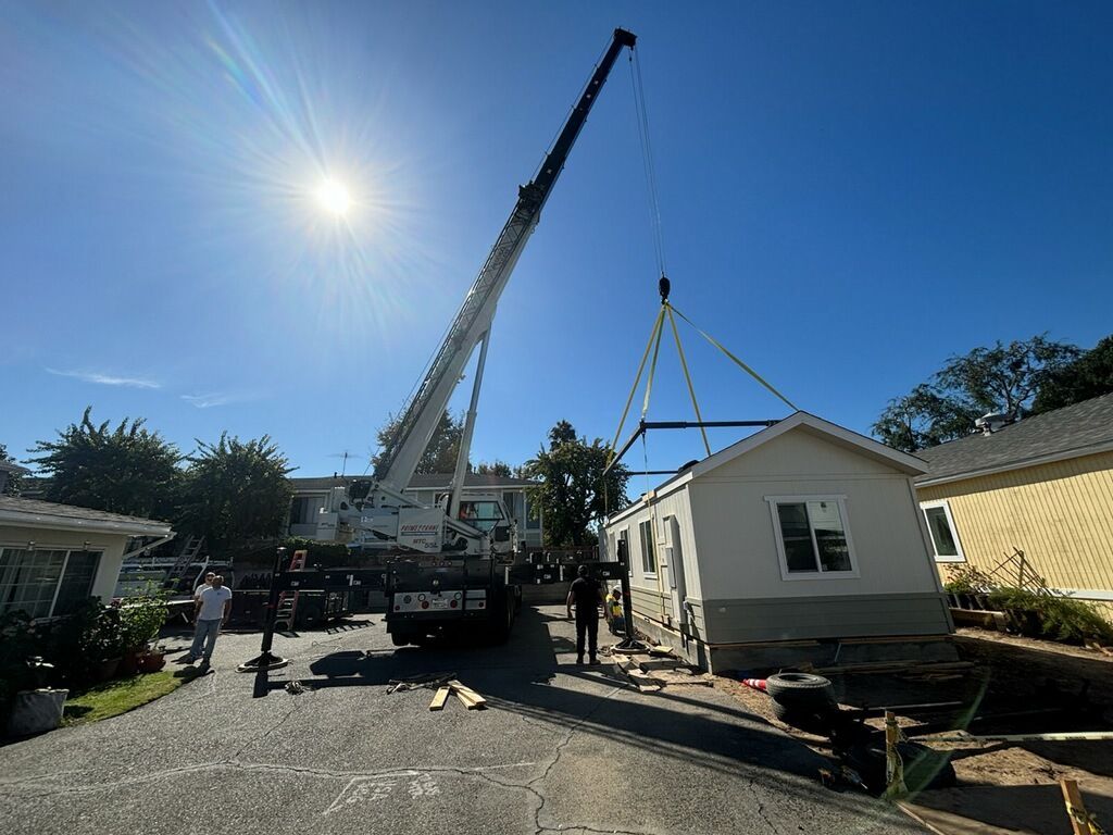 A crane is lifting a mobile home into place