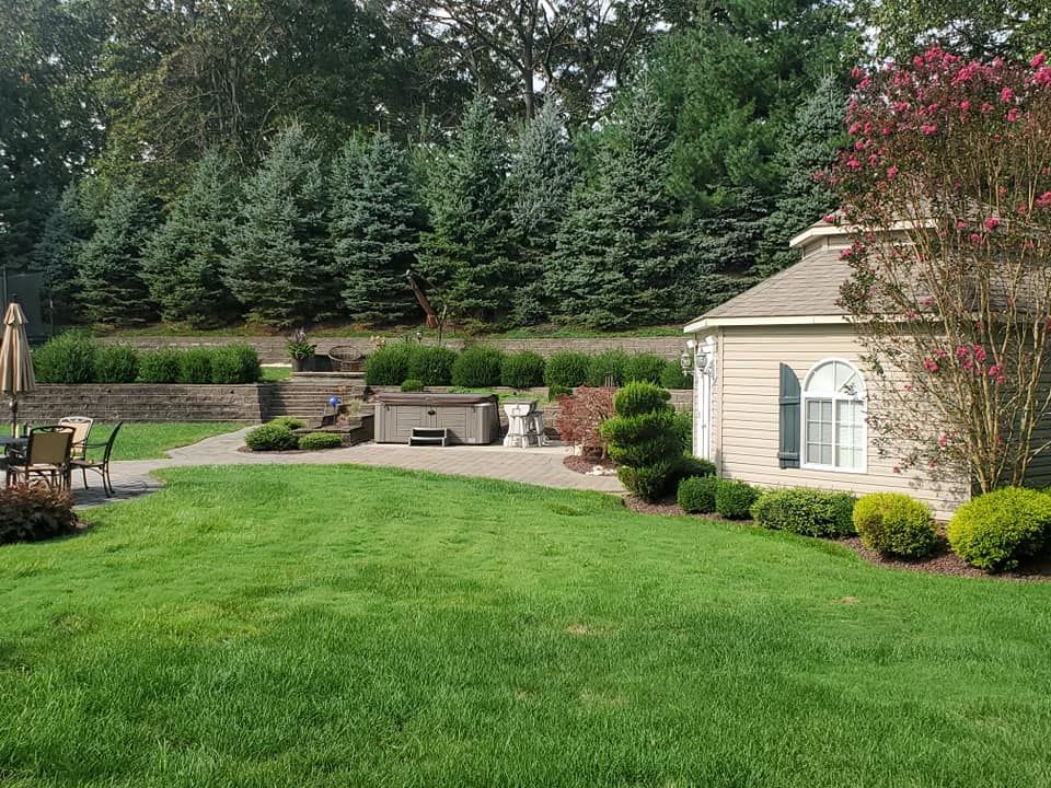 A house with a large lawn and a hot tub in the backyard.