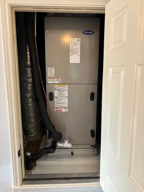 A carrier air conditioner is sitting inside of a doorway.