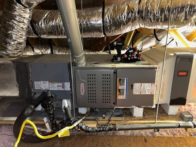 An air conditioner is sitting in the attic of a house.