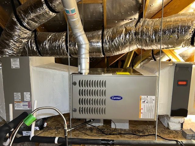 A carrier air conditioner is sitting in the attic of a house.