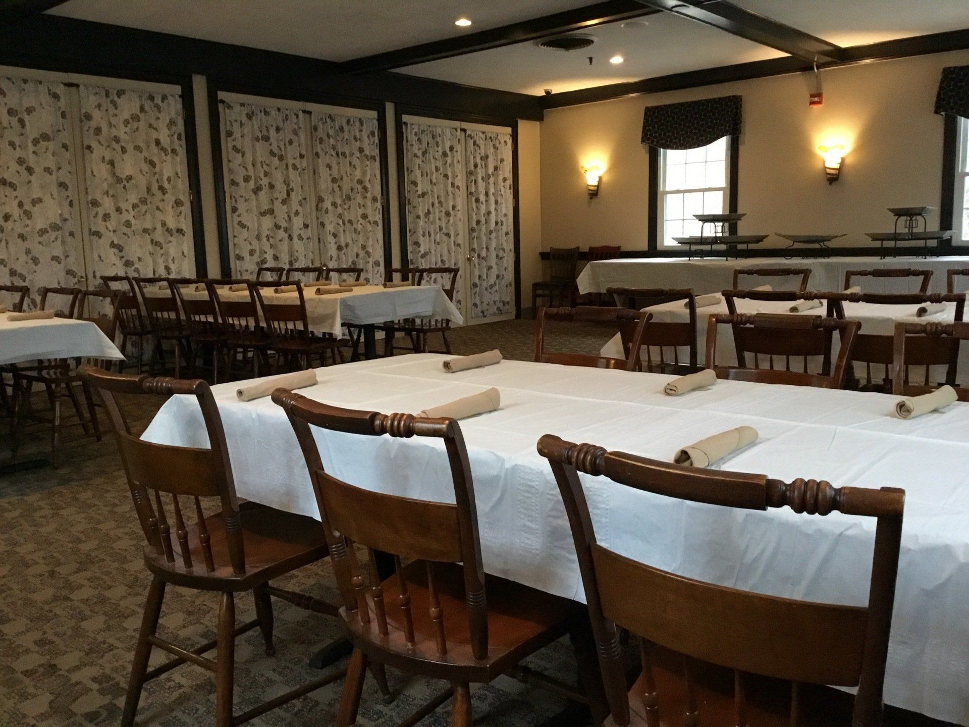 A dining room with tables and chairs and a window
