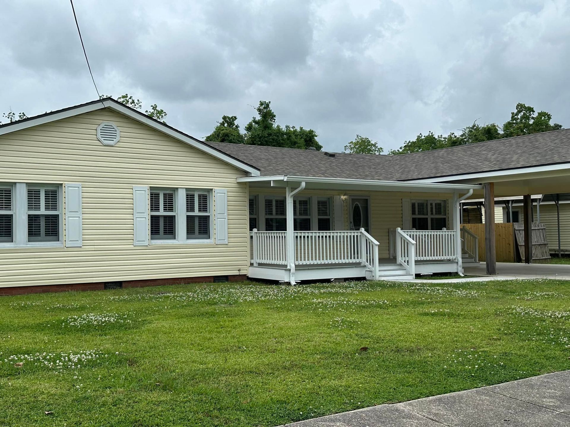A large white house with a porch and a lot of windows.