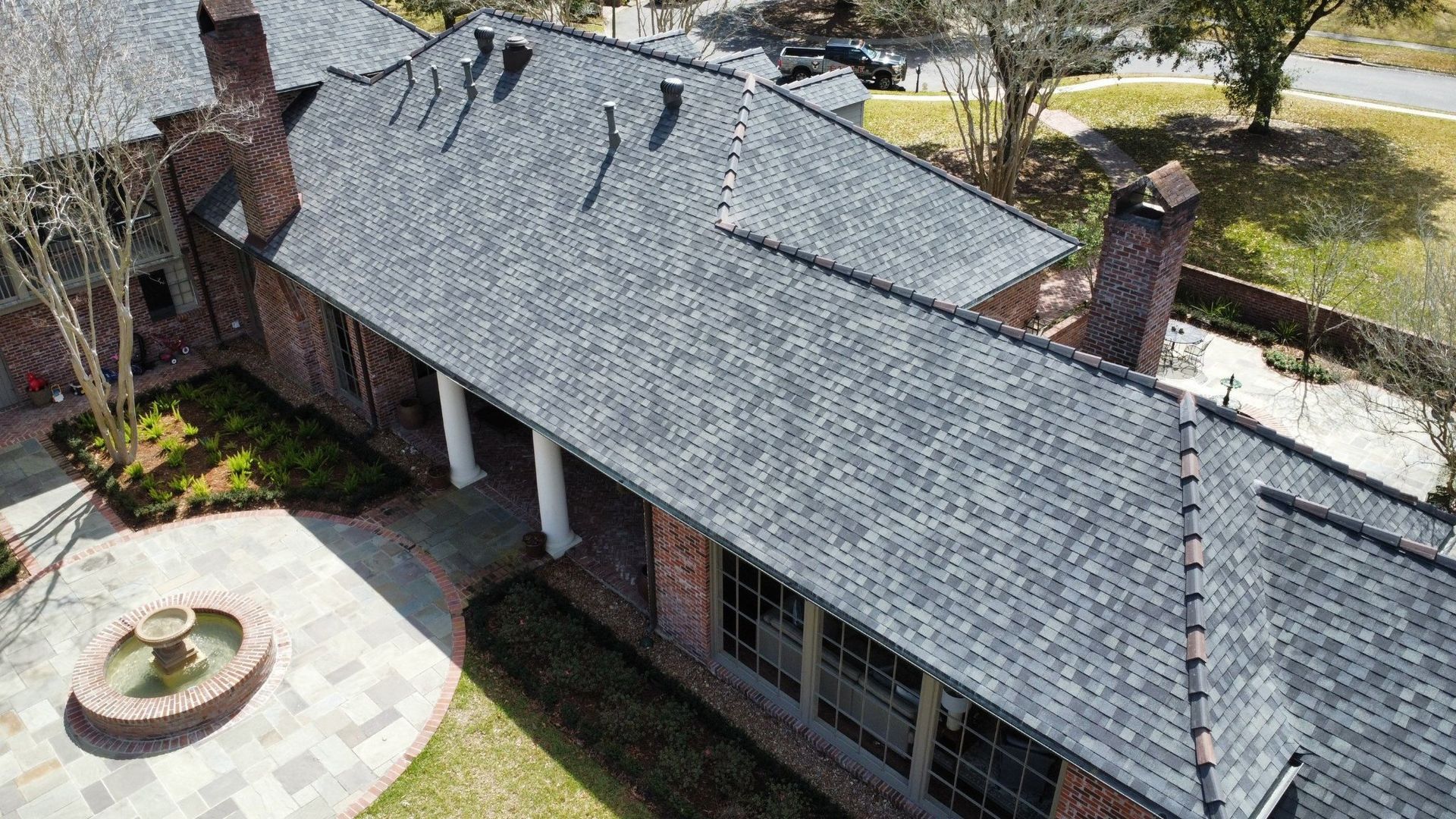 An aerial view of a large house with a gray roof.
