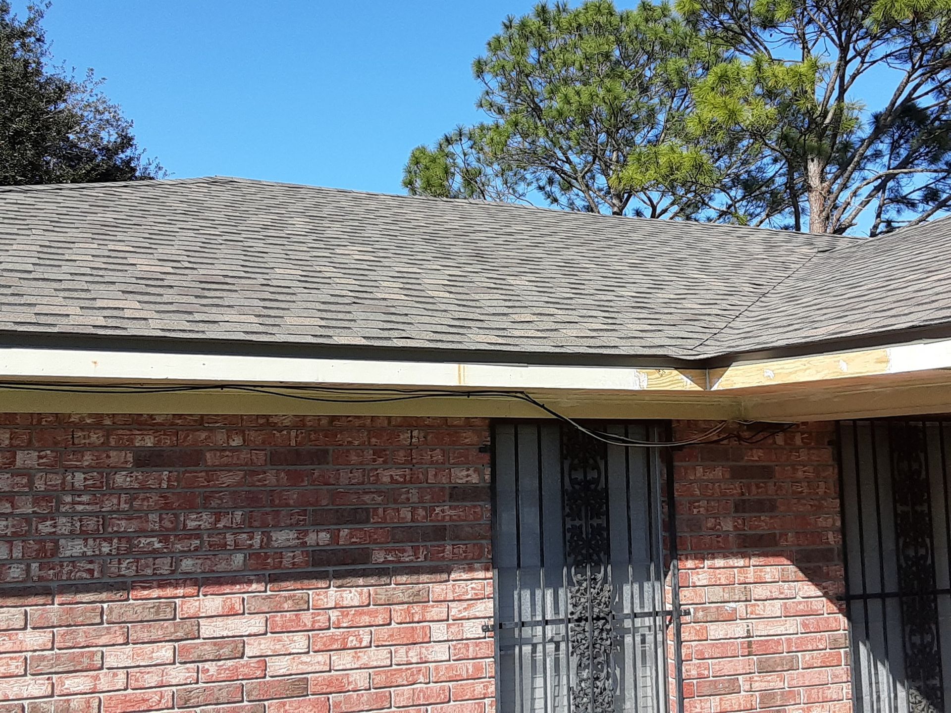 A brick house with a roof that is missing shingles