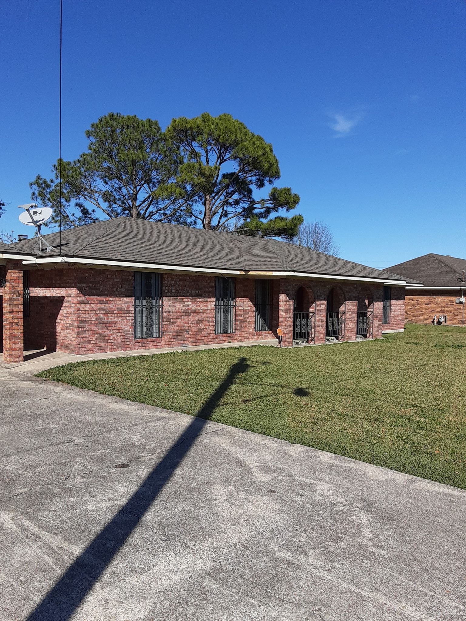 A brick house with a satellite dish on the roof is for sale.