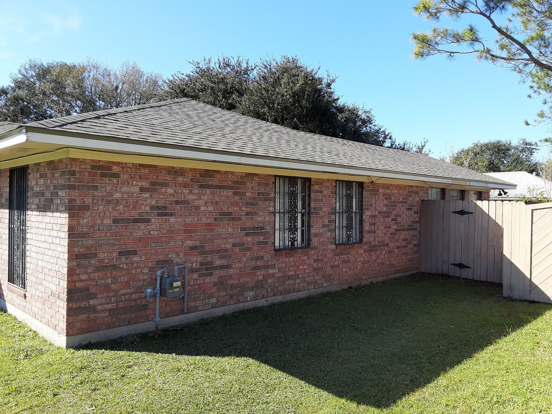 A brick house with a wooden fence in front of it