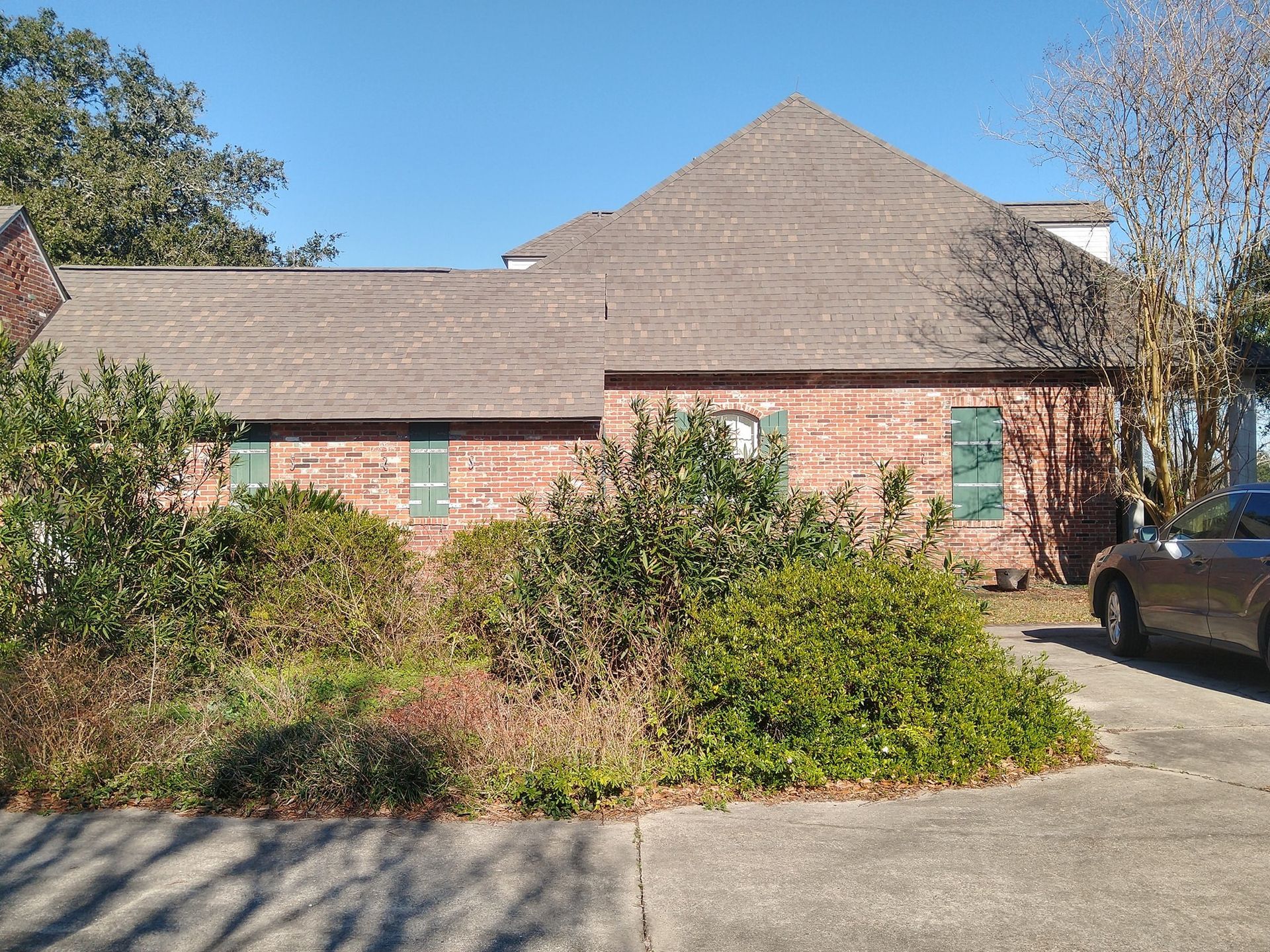 A brick house with a car parked in front of it