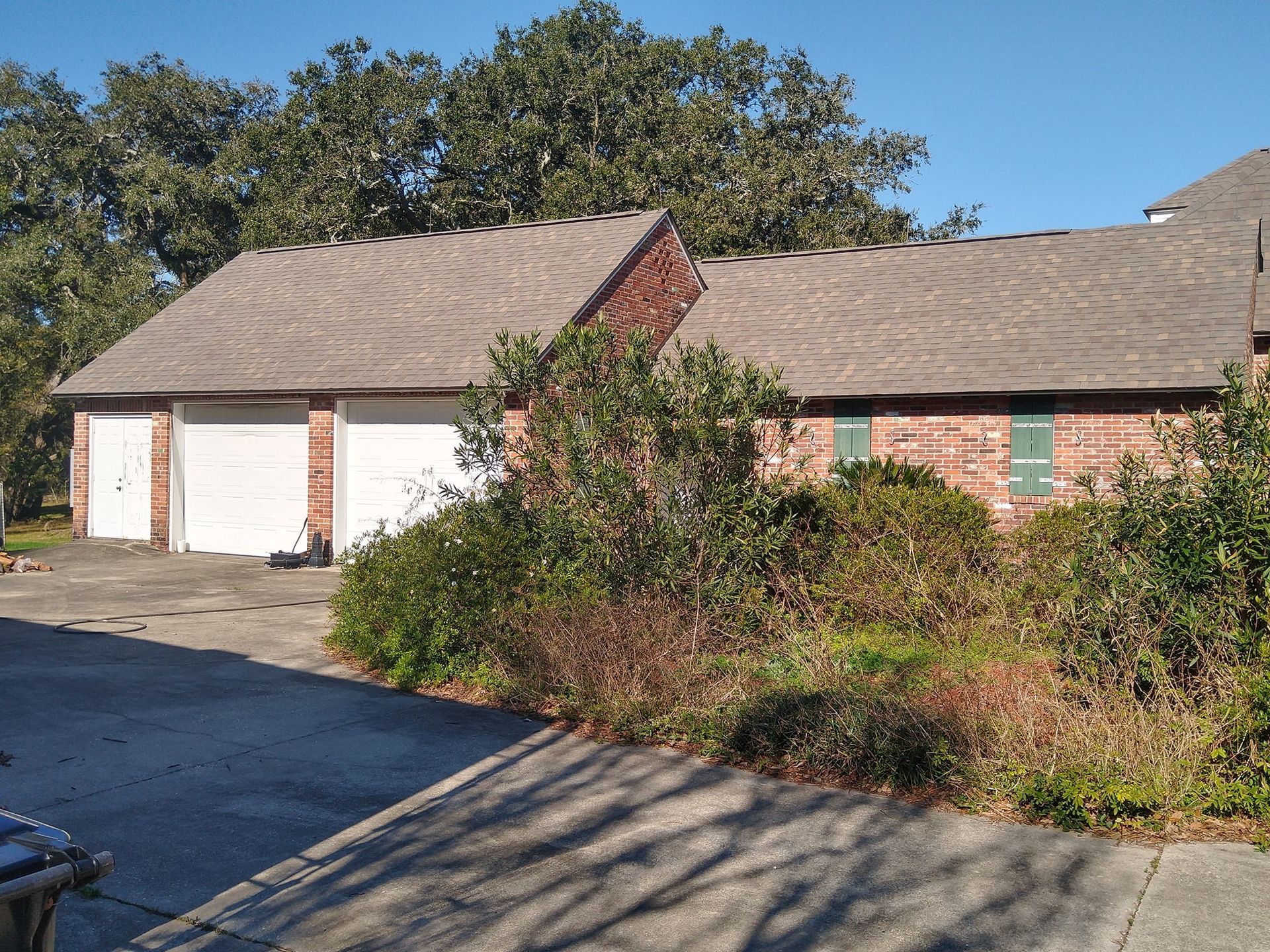 A brick house with two garage doors and a driveway
