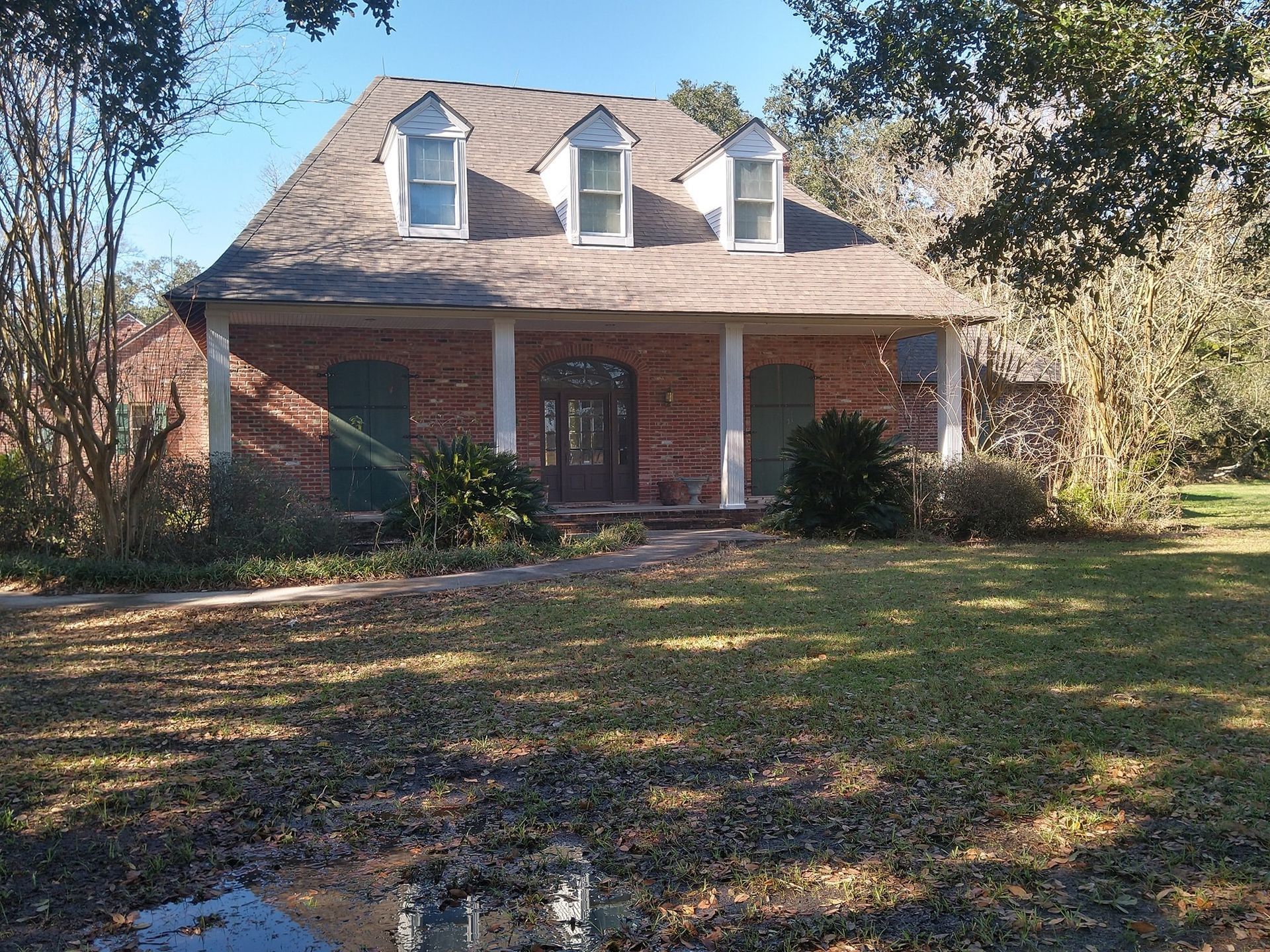 A large brick house with a porch and a roof