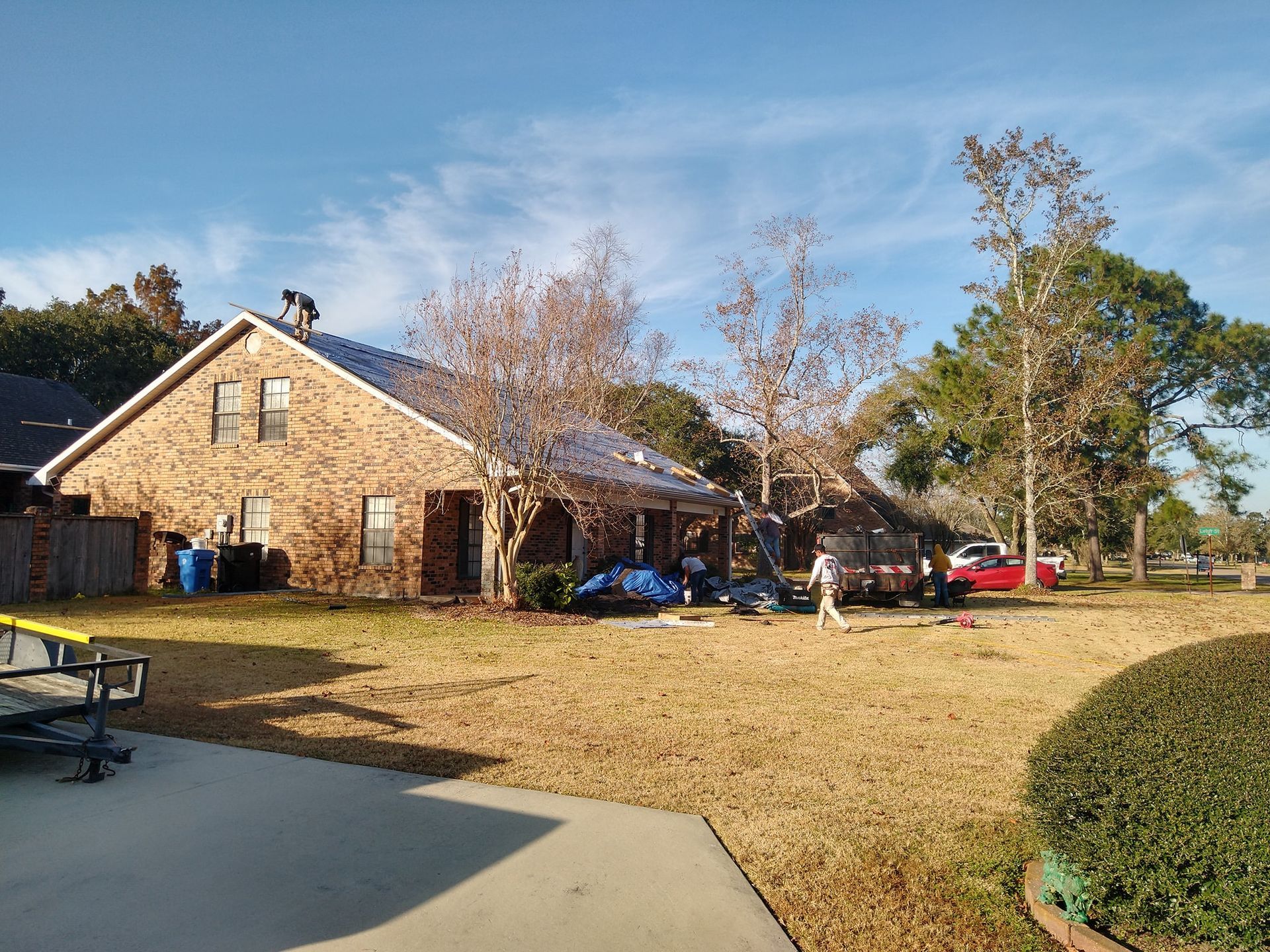 A group of people are working on a roof of a house.