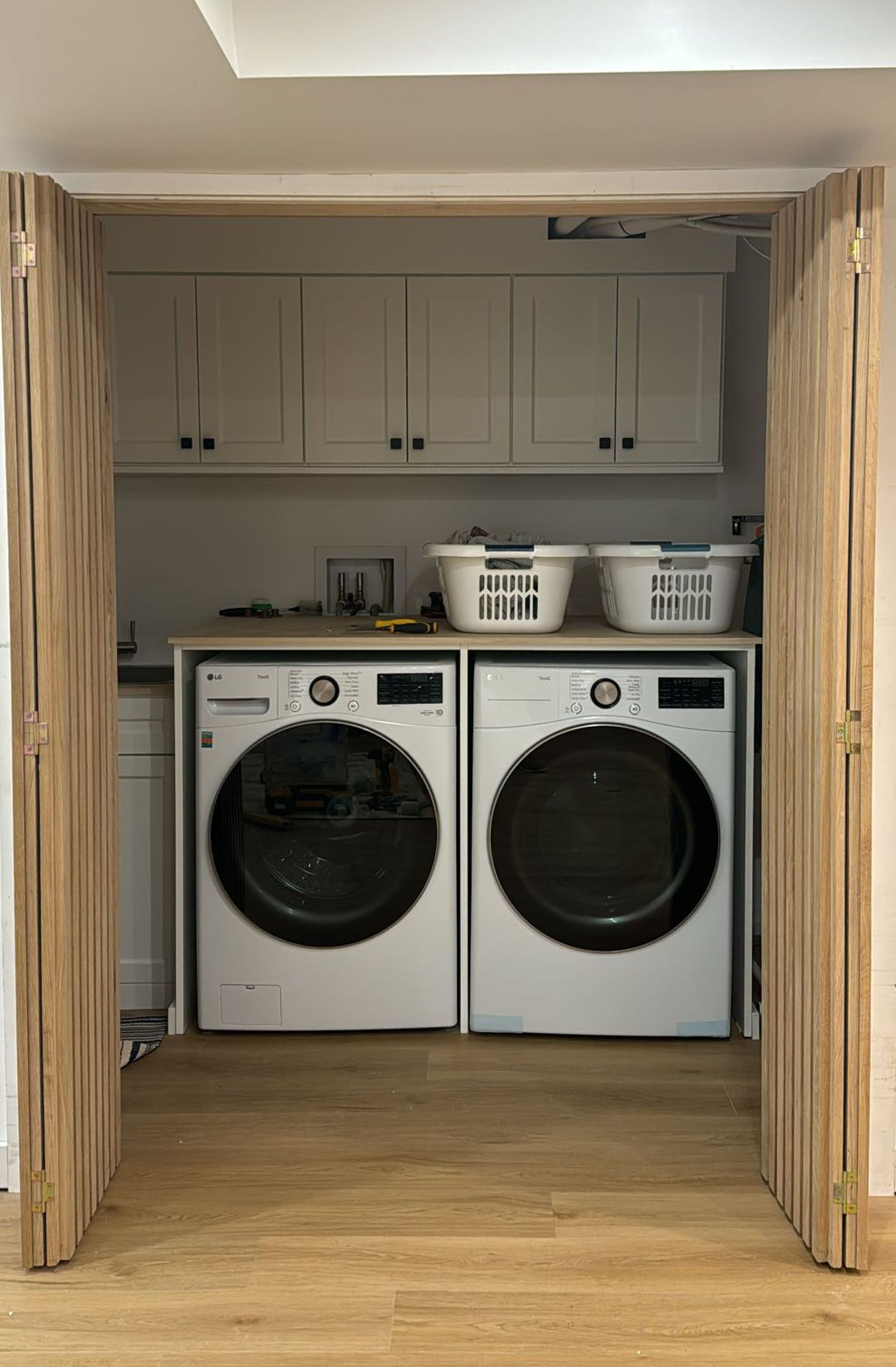 There are two washers and dryers in the laundry room.