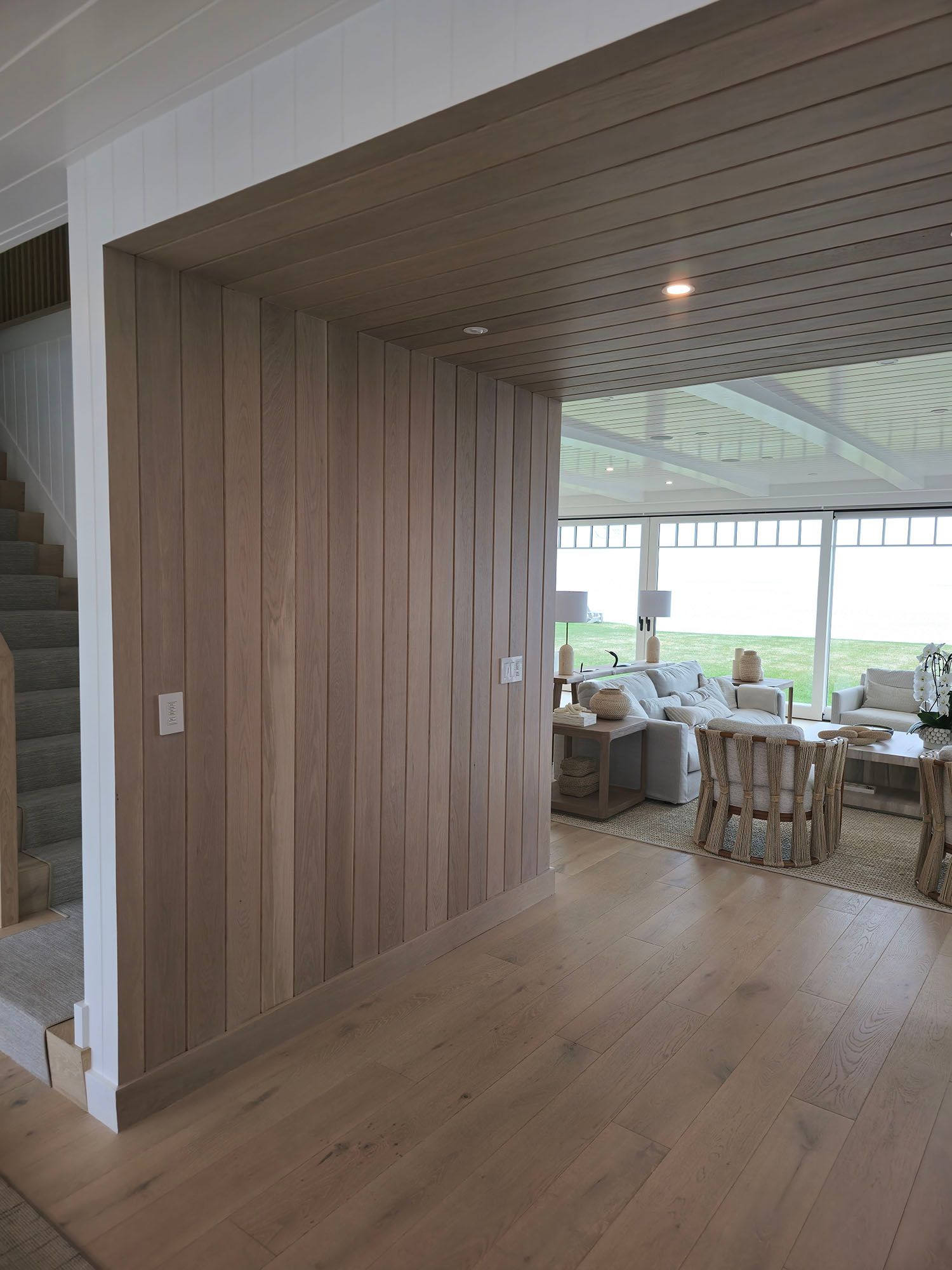 A large empty room with a wooden door and stairs.