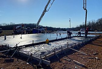 A concrete pump is pouring concrete on a construction site.