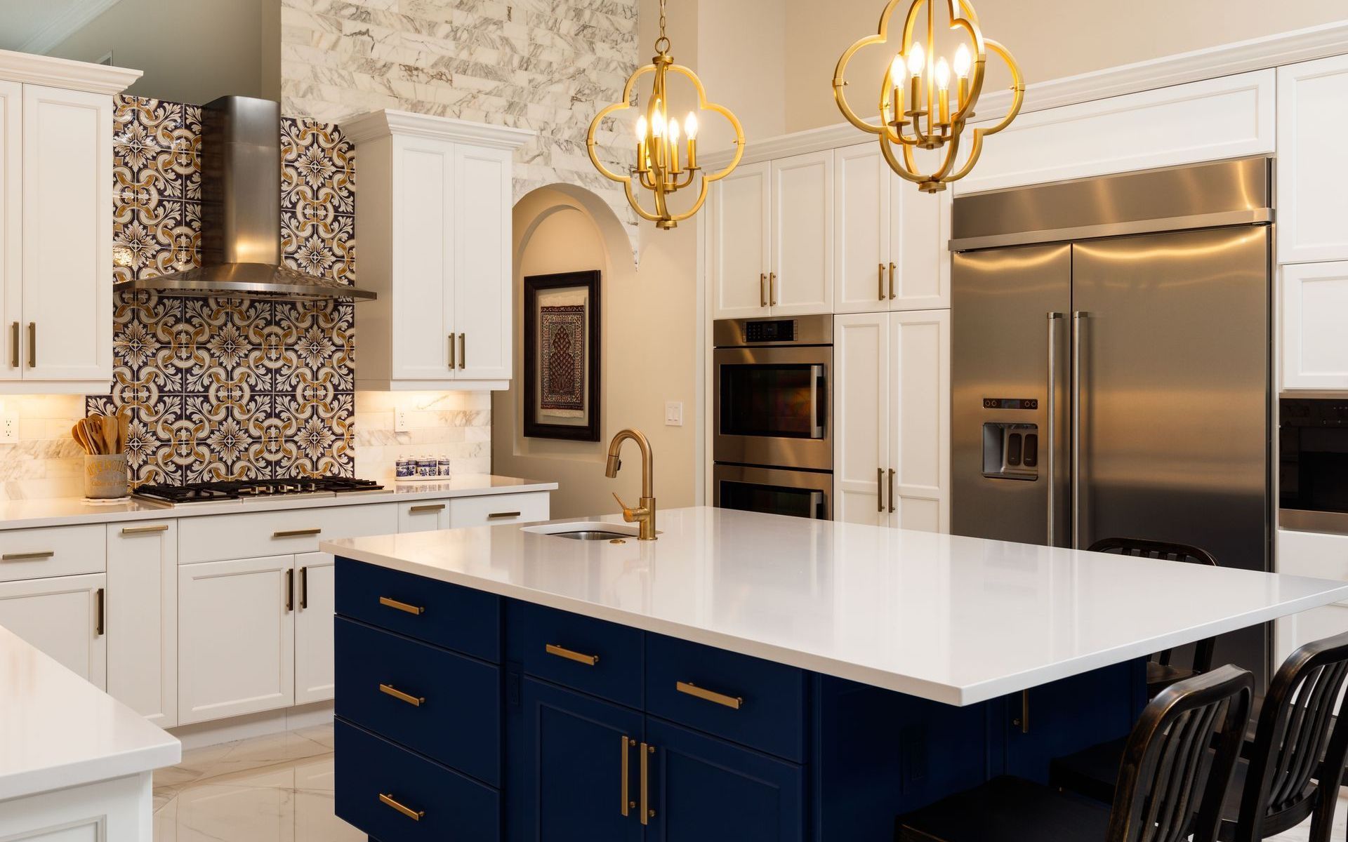 A kitchen with blue cabinets , white counter tops , stainless steel appliances and a large island.