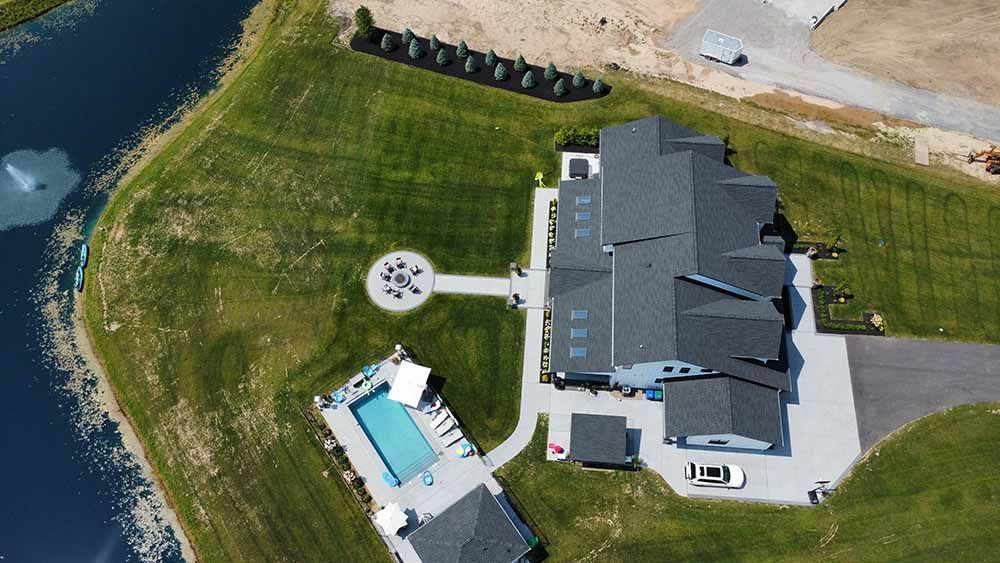 An aerial view of a large house with a pool in the backyard.