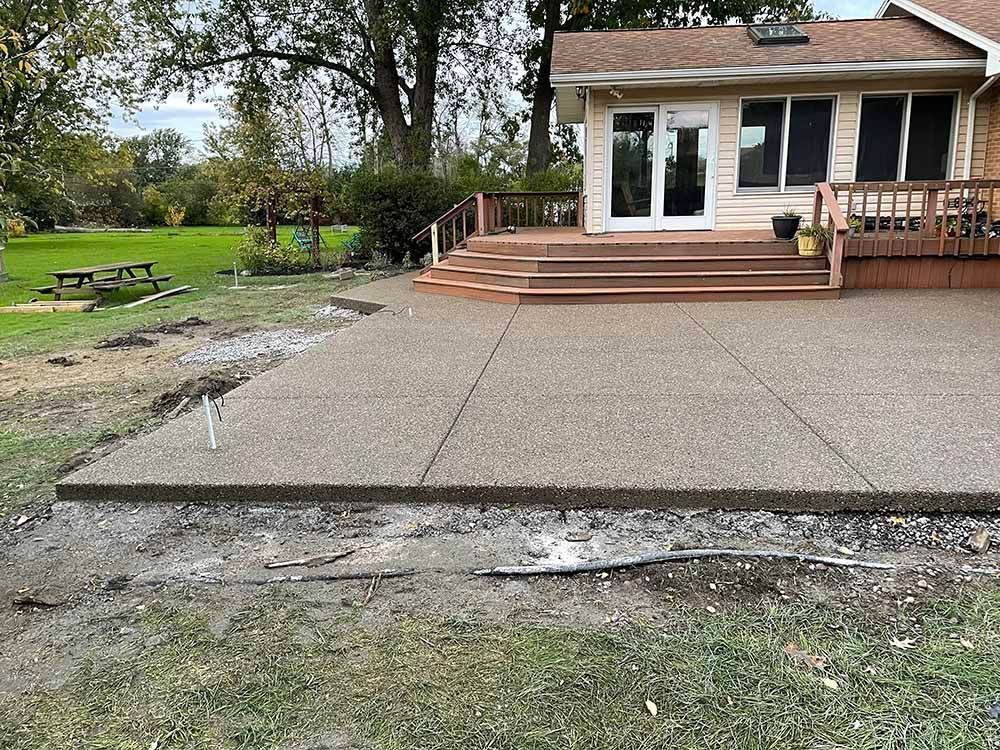 A concrete patio is being built in front of a house.