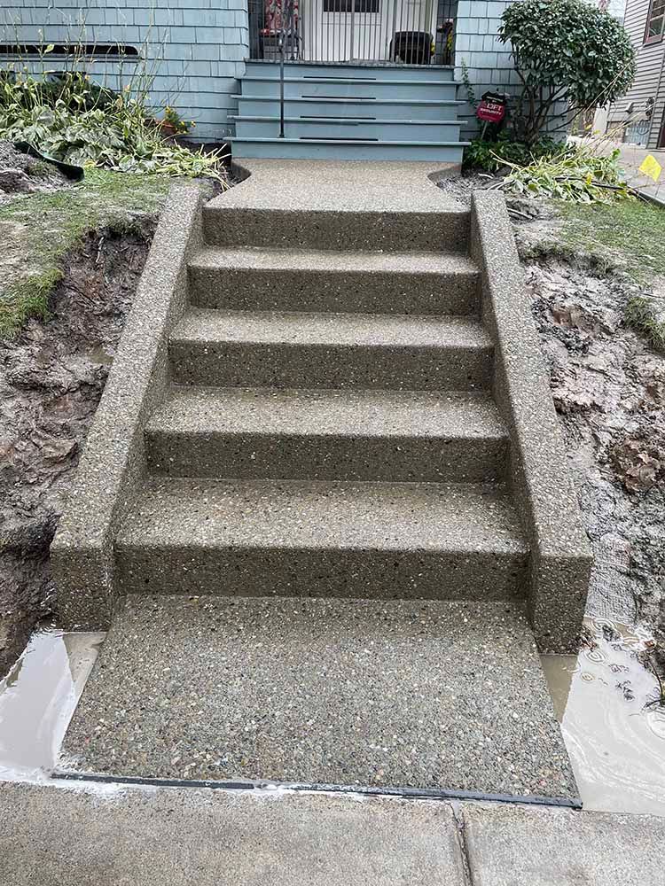 A set of concrete stairs leading up to a house.