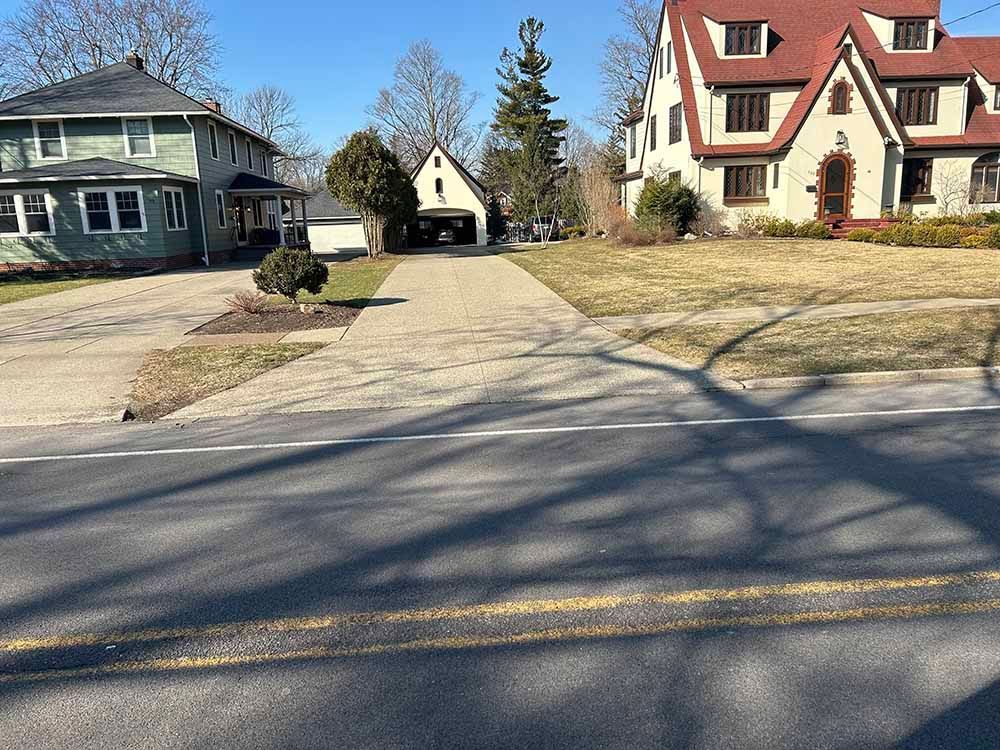 A couple of houses are sitting next to each other on the side of a road.
