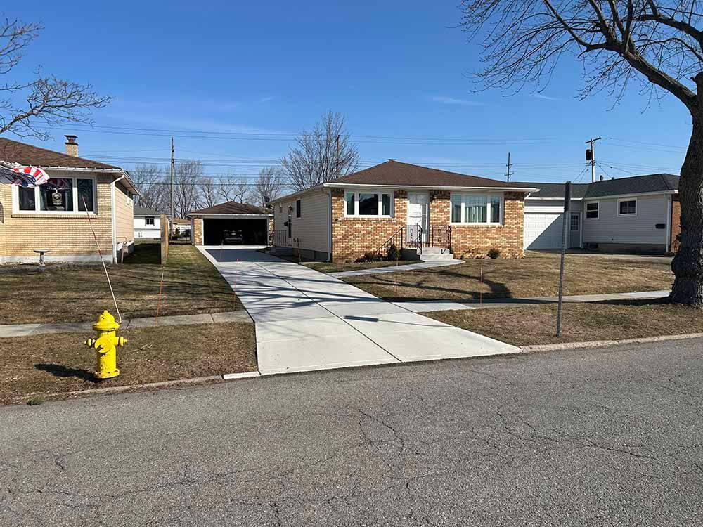 A fire hydrant is in front of a house in a residential area.