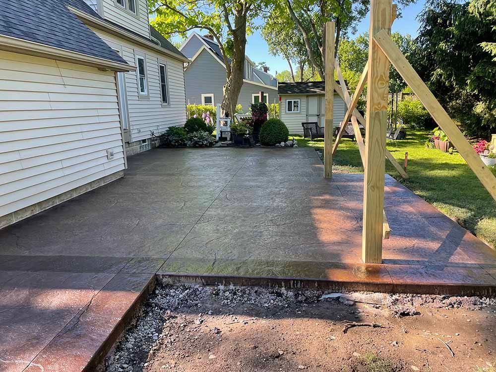 A concrete driveway is being built in front of a house.