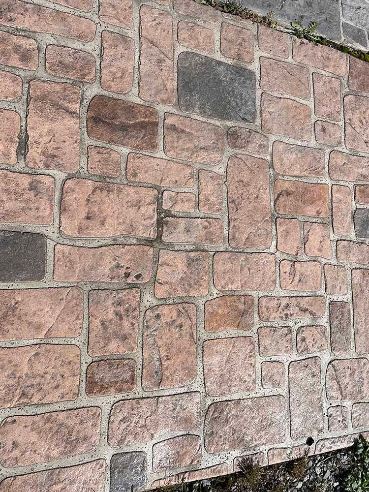 A close up of a brick wall on a sidewalk.