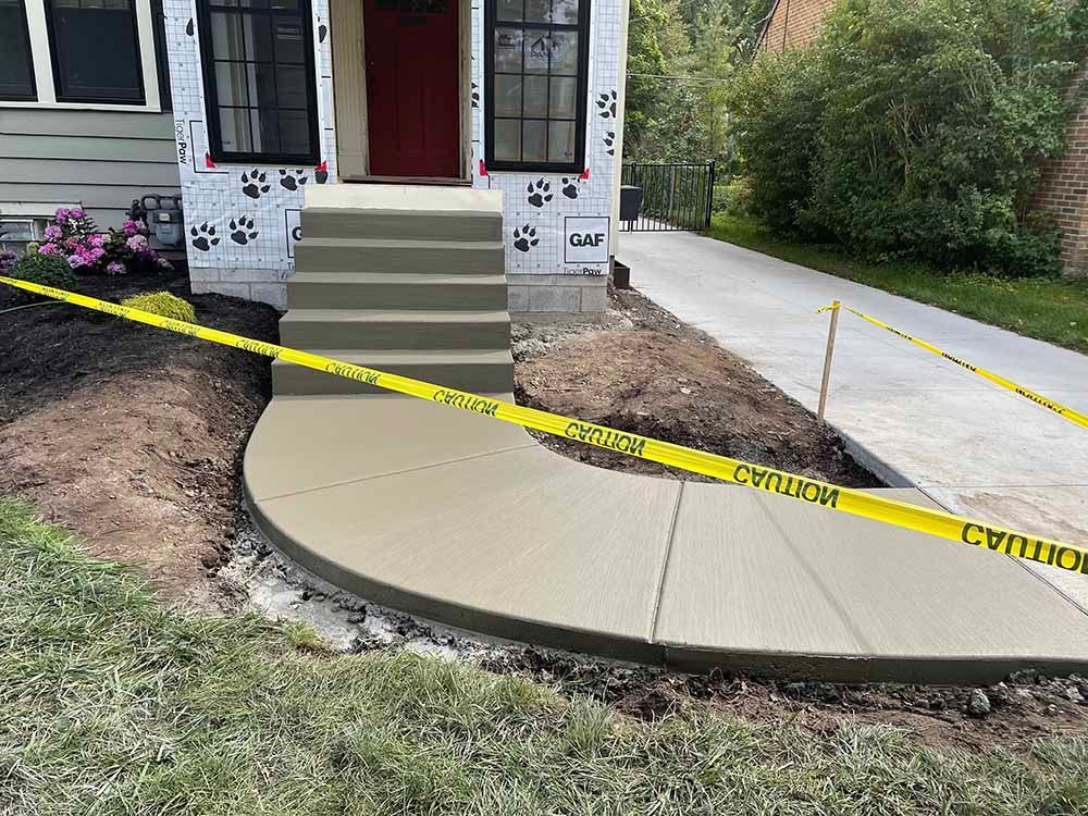 A concrete walkway is being built in front of a house.