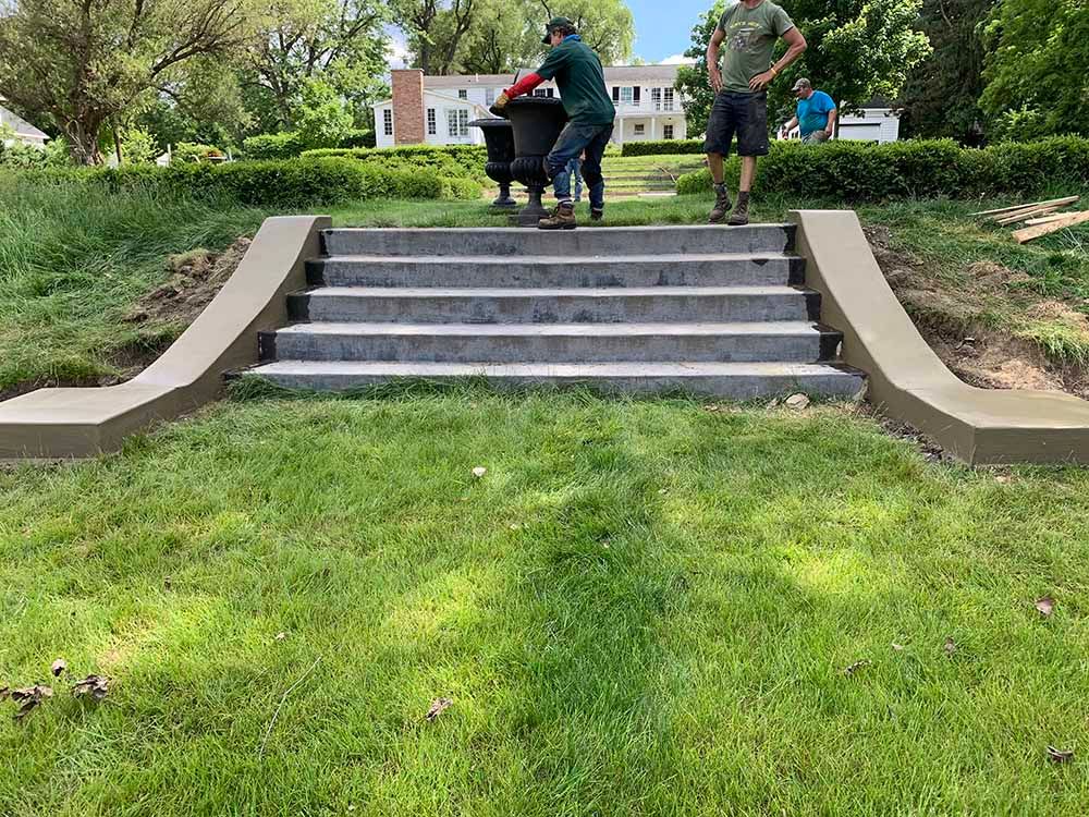 Two men are standing on a set of stairs in a park.