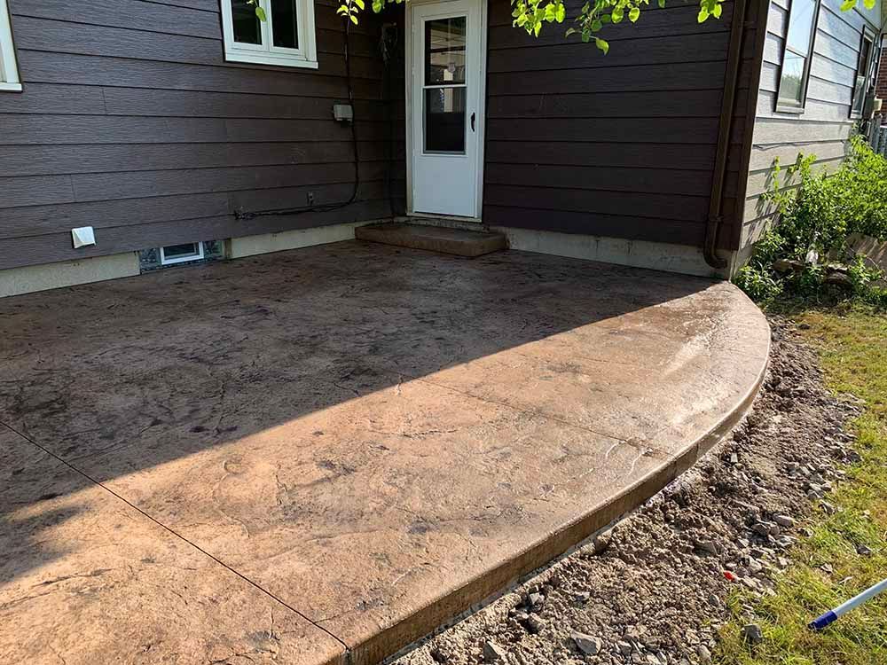 A concrete walkway leading to the front door of a house.