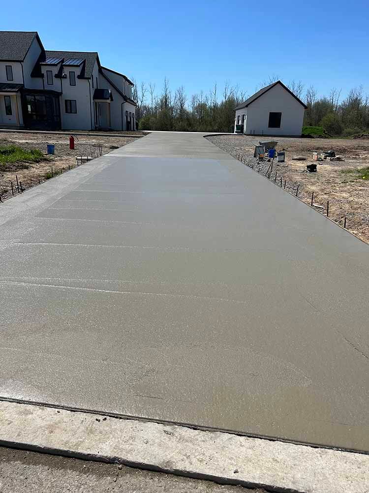 A concrete driveway is being built in front of a house.