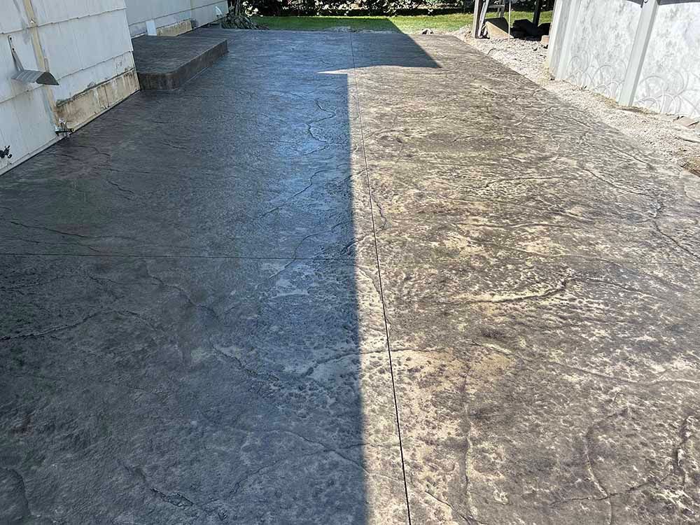 A concrete driveway with steps leading to a house.