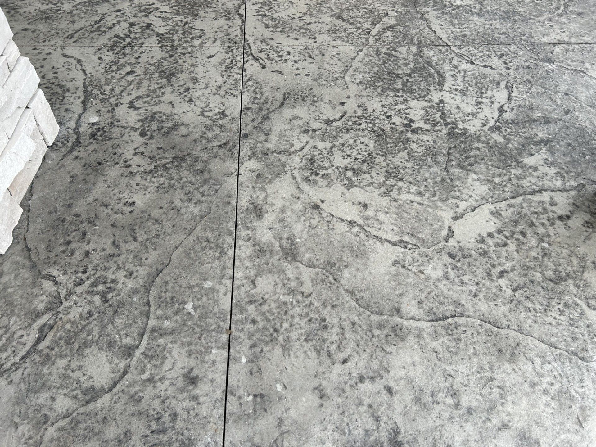 A close up of a concrete floor with a brick wall in the background.