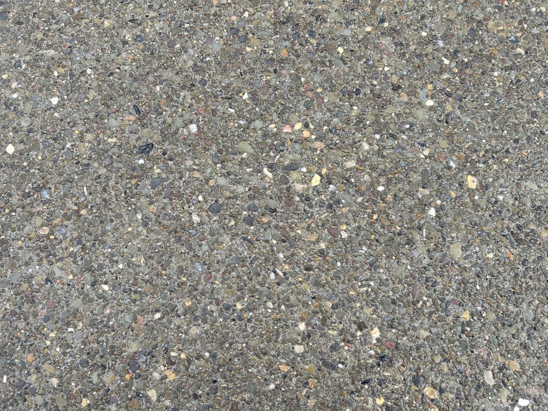 A close up of a concrete surface with a lot of small rocks on it.