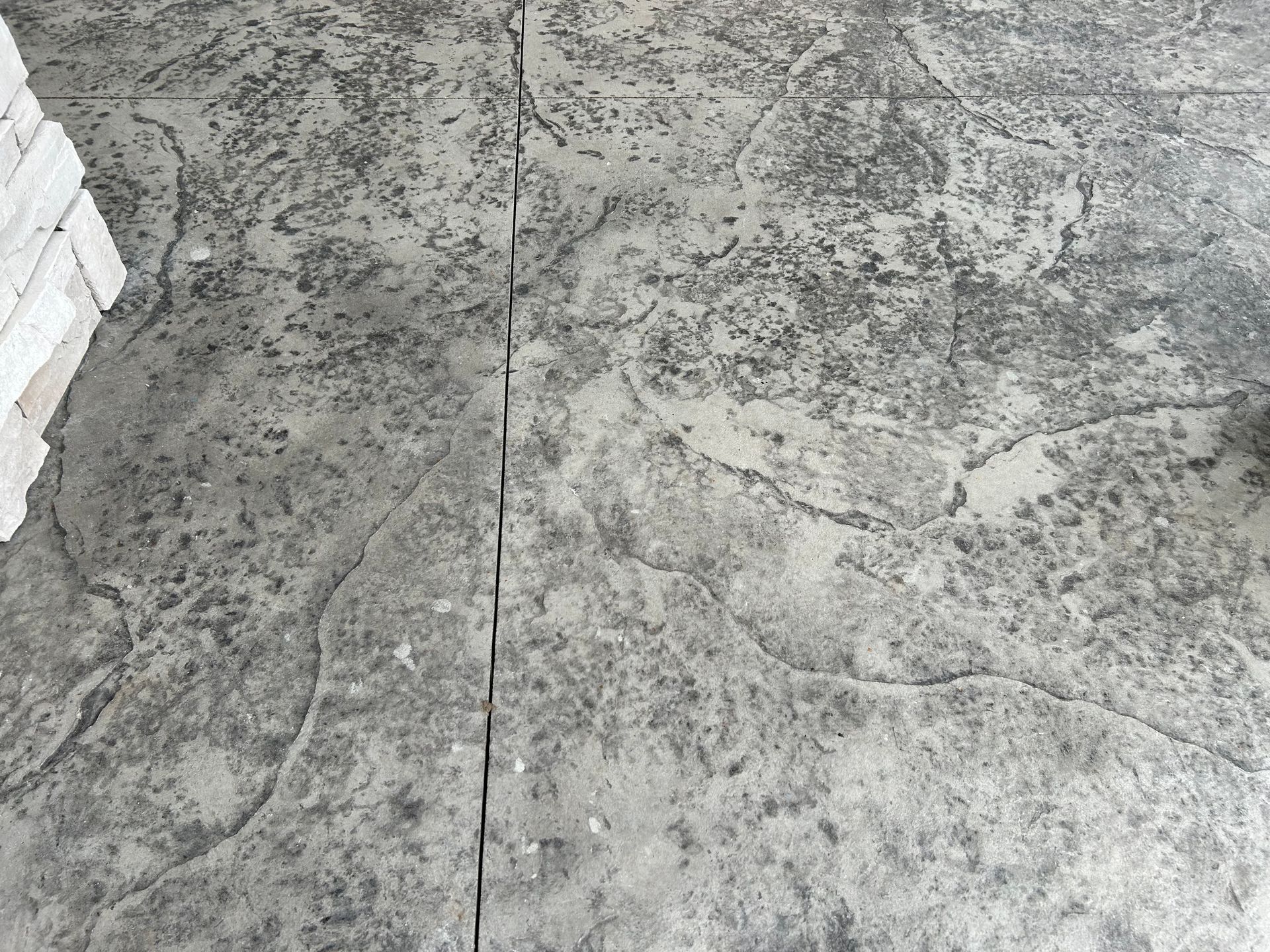 A close up of a concrete floor with a brick wall in the background.