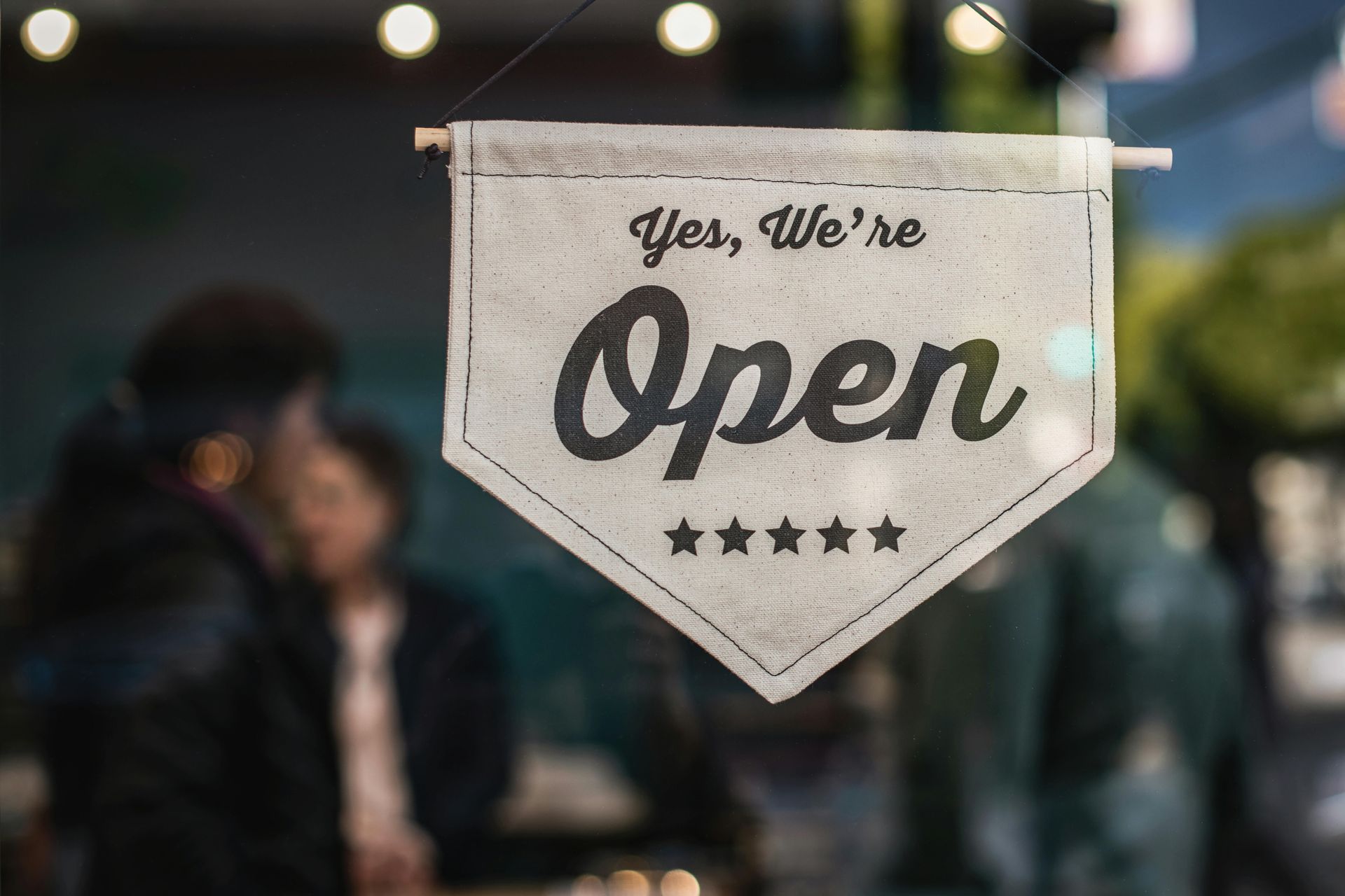 Yes we are open sign hanging in a business window