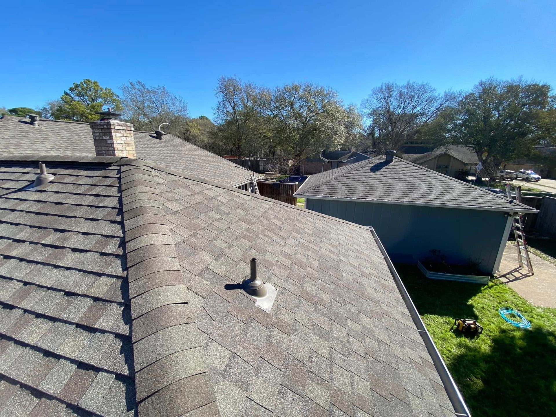 Overhead view of several residential rooftops on a sunny day.